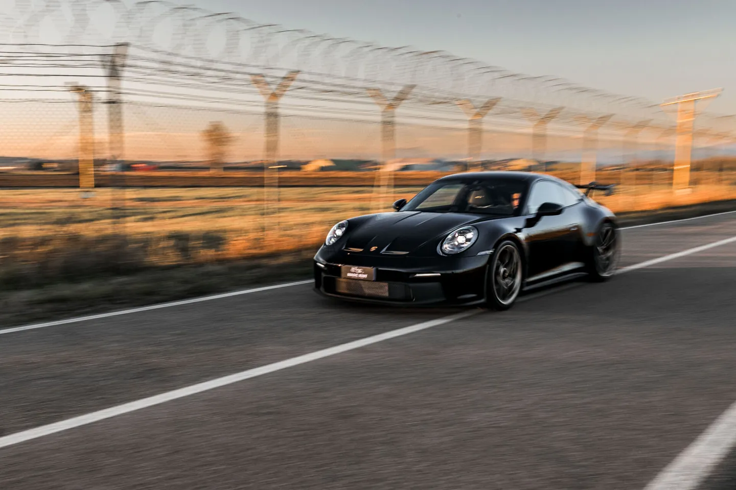 Porsche nera in movimento su una strada di campagna