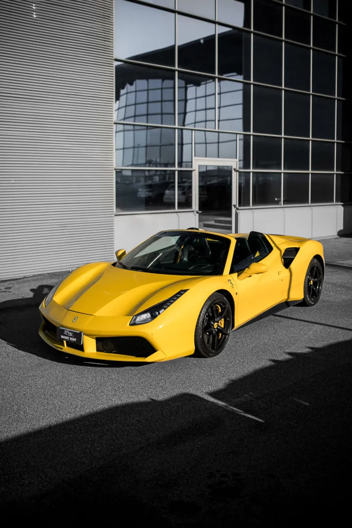 Ferrari gialla scoperta davanti a un edificio moderno