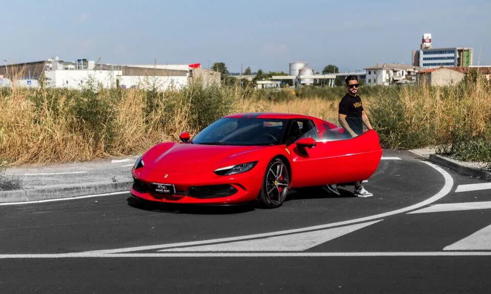Ferrari rossa con la portiera aperta e una persona accanto