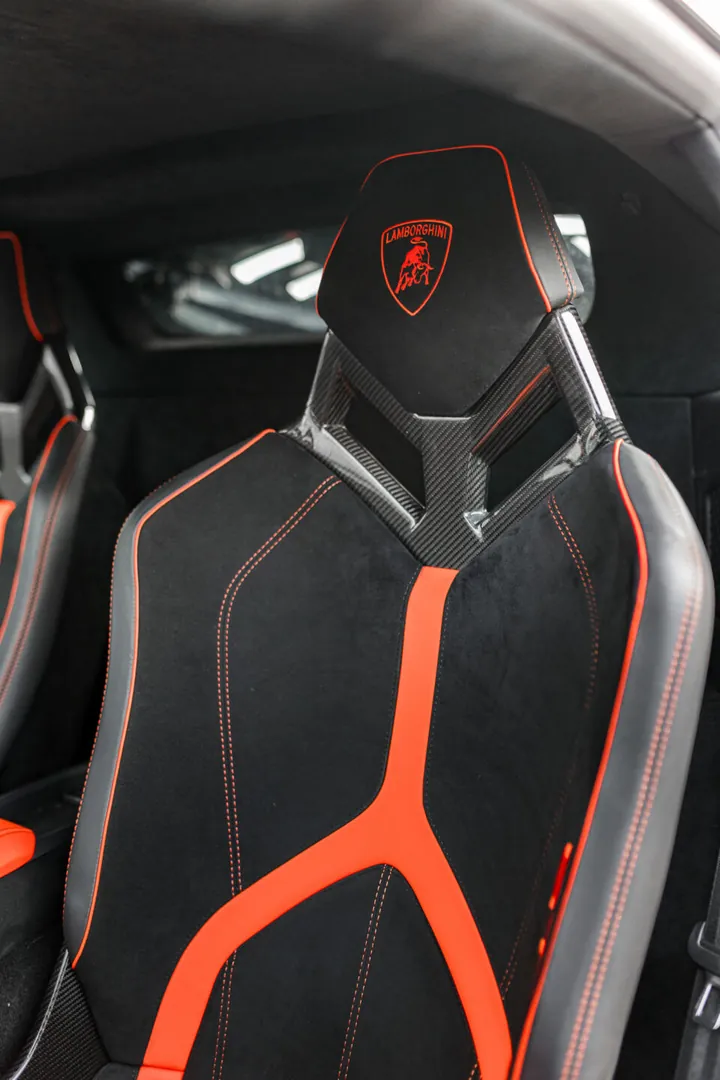 Sedile sportivo nero e arancione con lo stemma Lamborghini