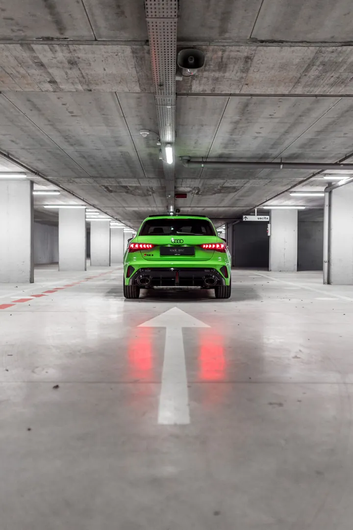 Audi verde vista da dietro, in fondo a un parcheggio coperto
